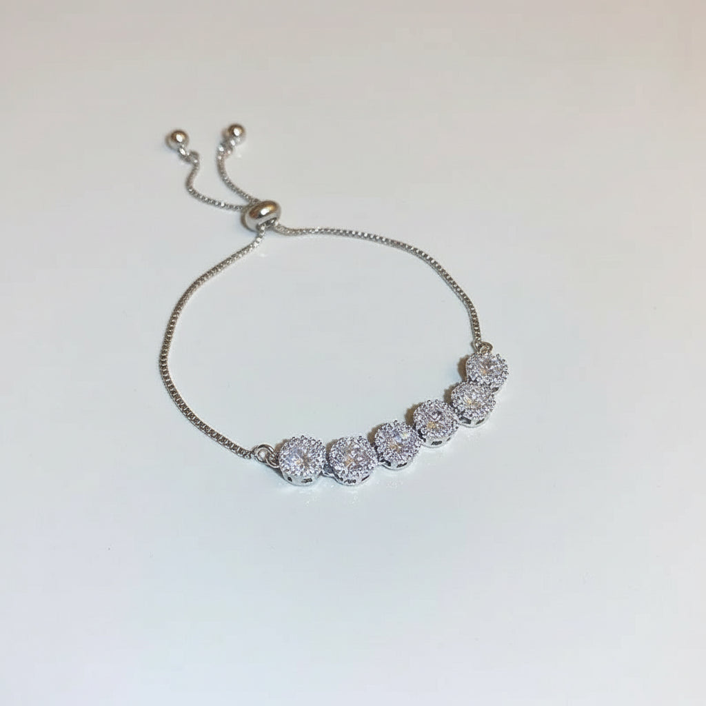 Silver bracelet with clear stones on a white background
