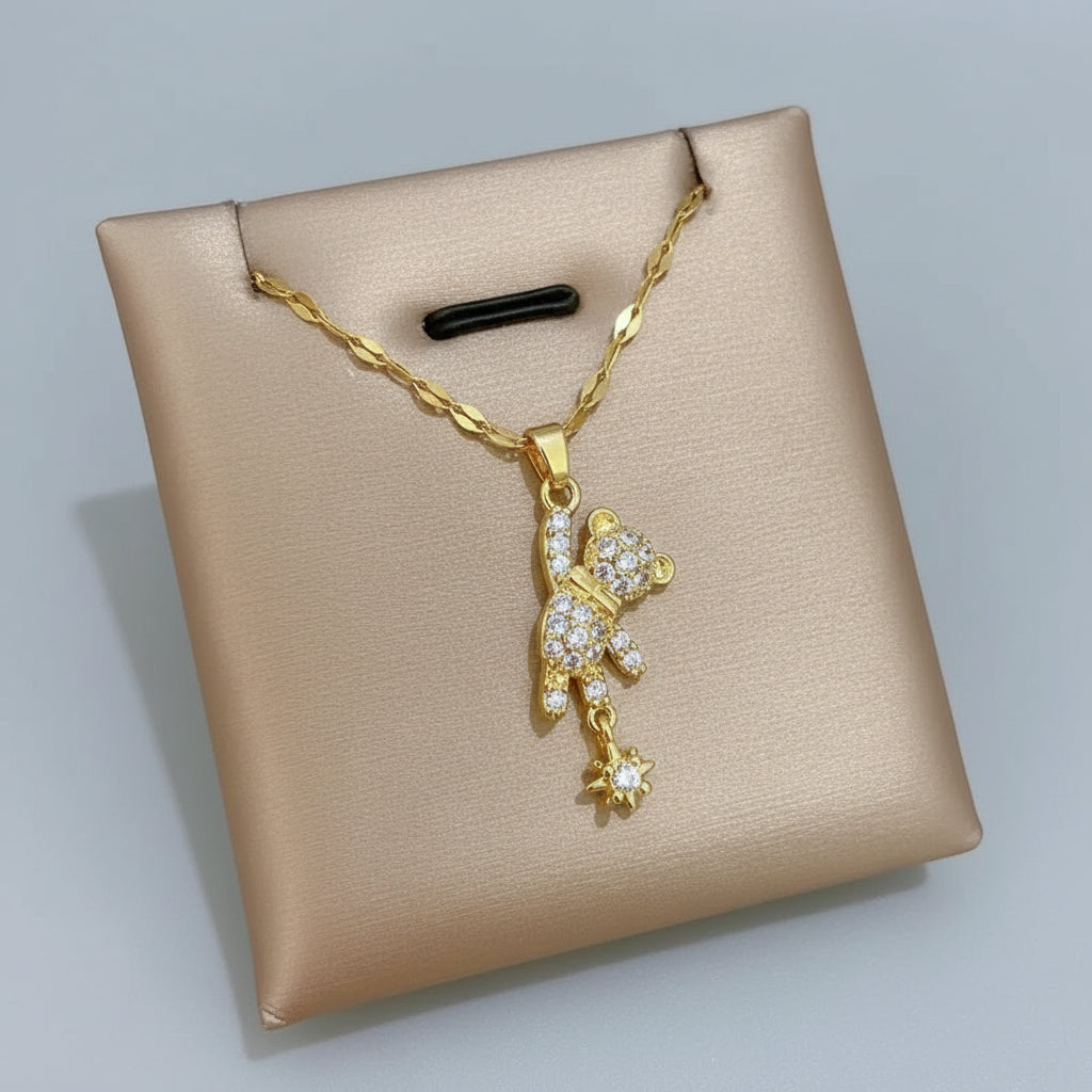 Gold necklace with a bear pendant on a beige box