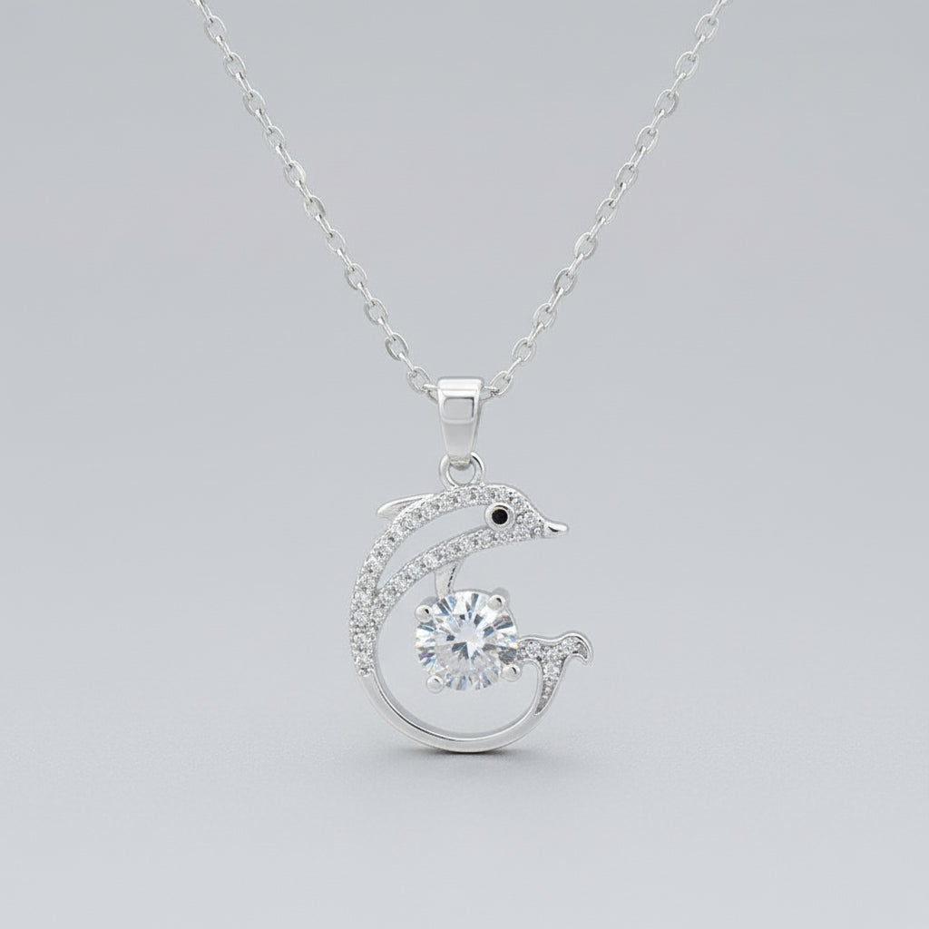Silver dolphin pendant necklace on a gold background