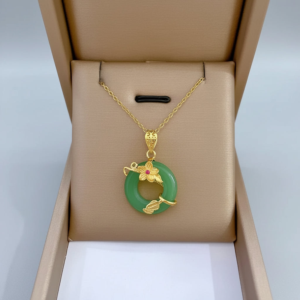 Gold necklace with a green pendant in an open jewelry box