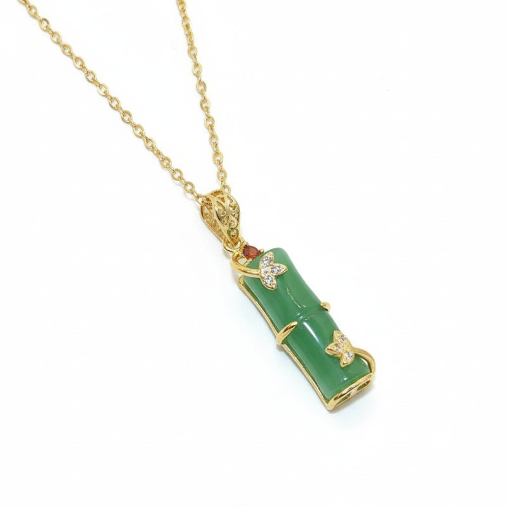 Green pendant necklace with gold chain on a beige background